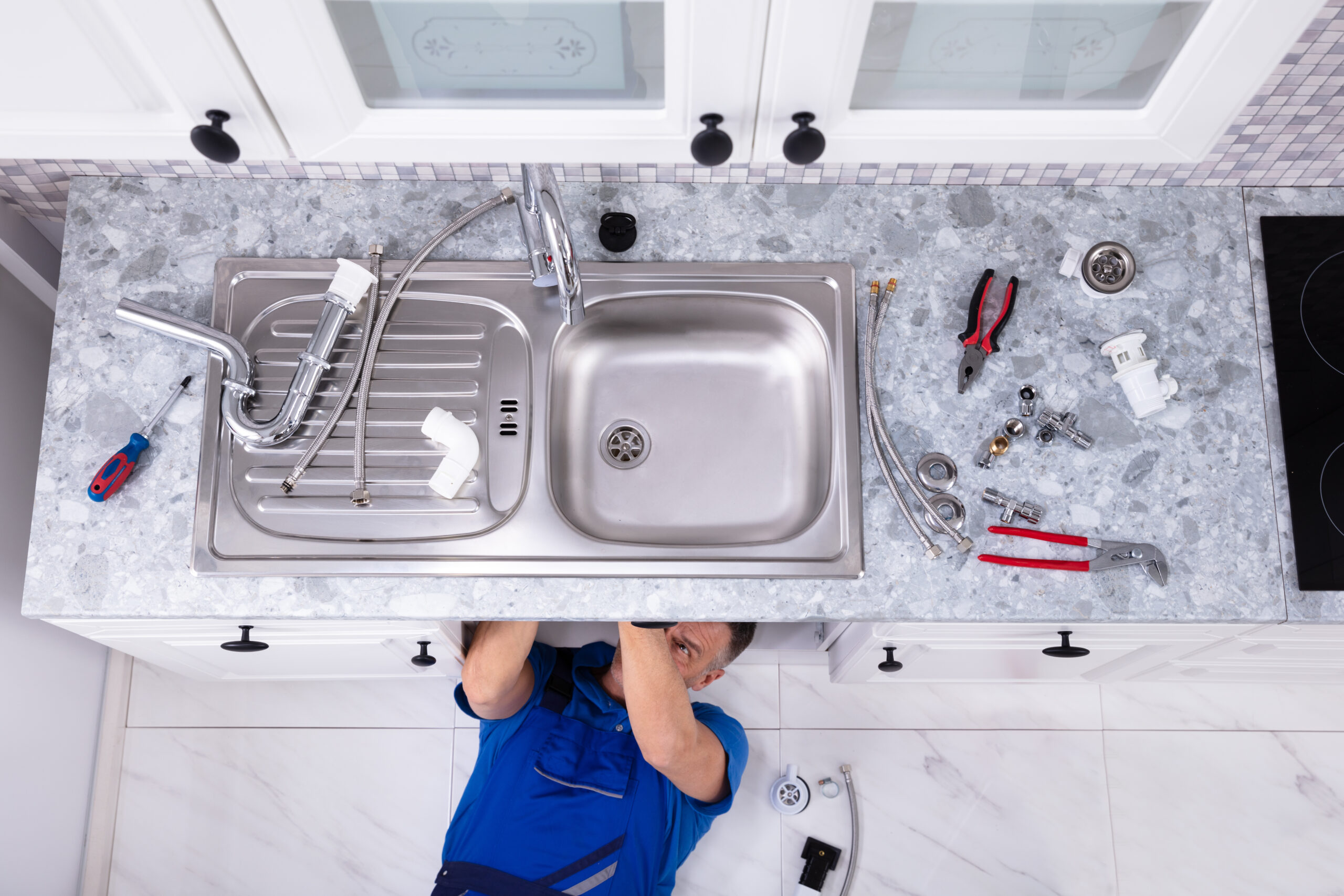 handyman repairing sink pipe